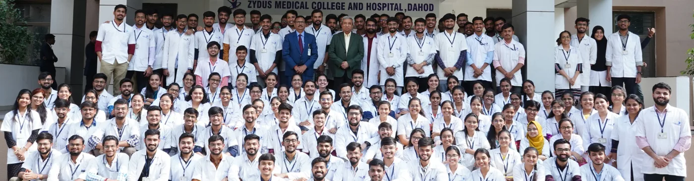 MBBS cohort of Zydus Medical College and Hospital in white coats in front of the main building at Dahod